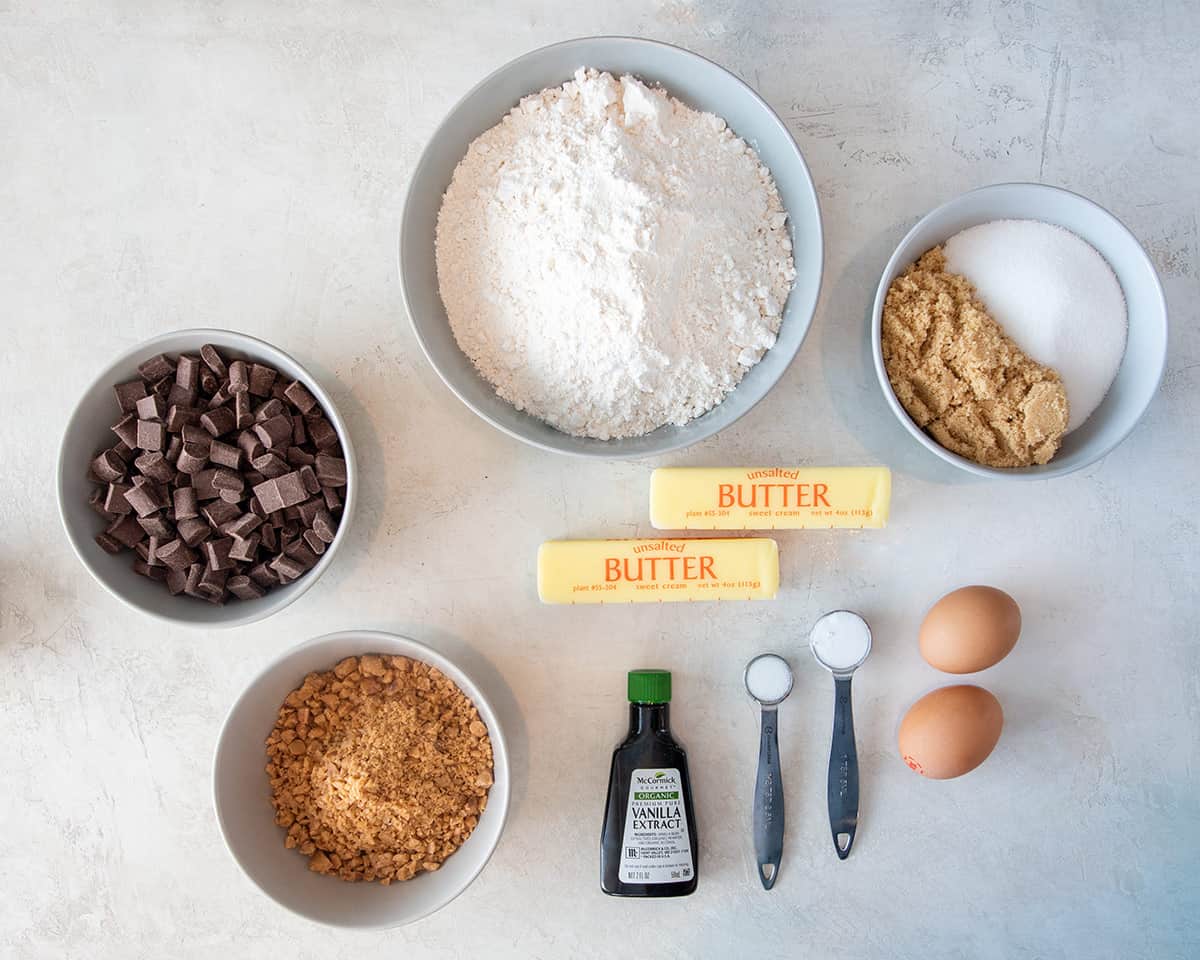 Ingredients to make toffee chocolate chunk cookies laid out on a table.