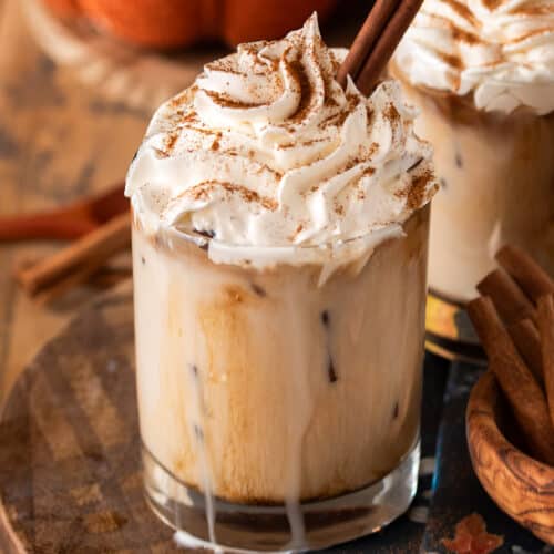 Pumpkin spice white Russian with whipped cream on top and a cinnamon stick.