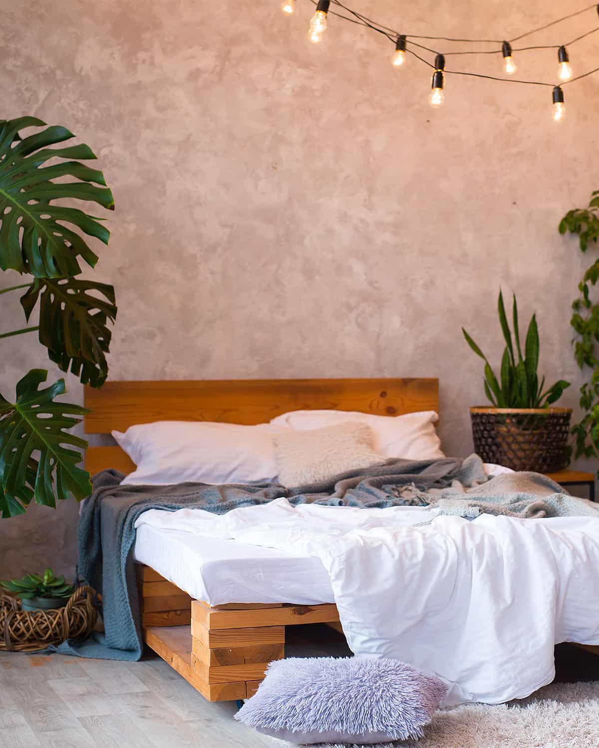 Cement textured feature wall adds an aged vintage vibe to this industrial style bedroom.