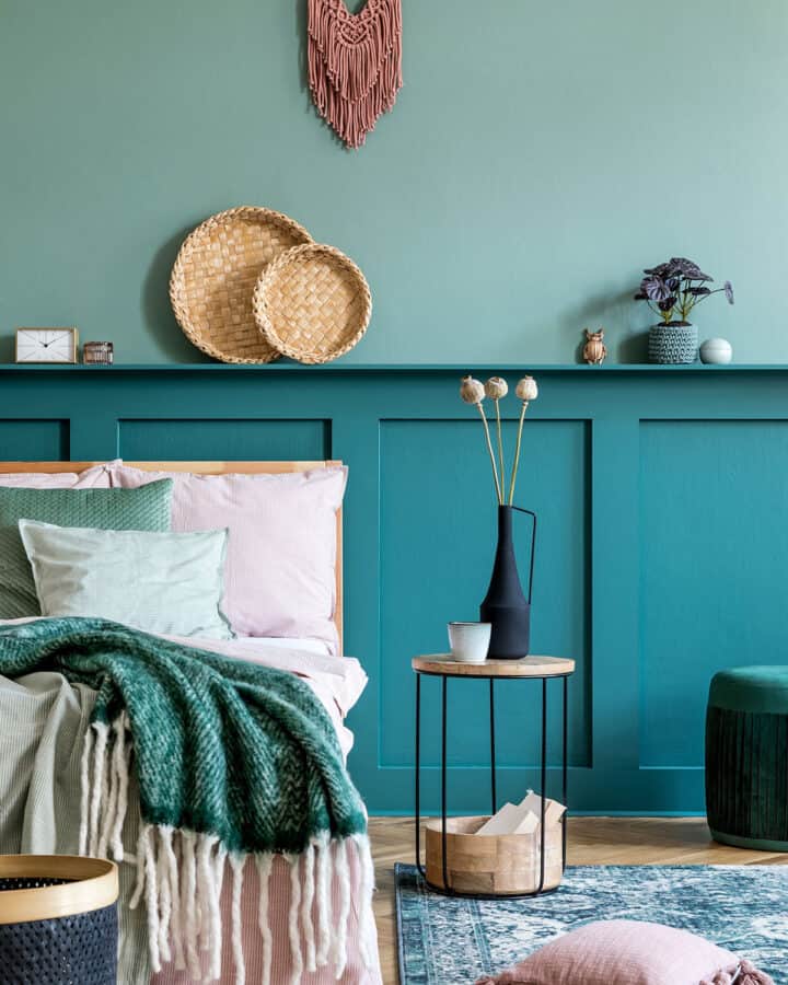 Two-tone feature wall in bold shades of teal board and batten in a boho bedroom.