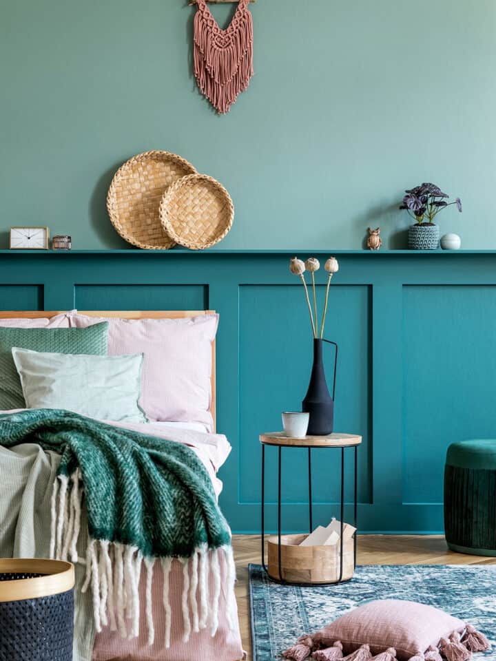 Two-tone feature wall in bold shades of teal board and batten in a boho bedroom.
