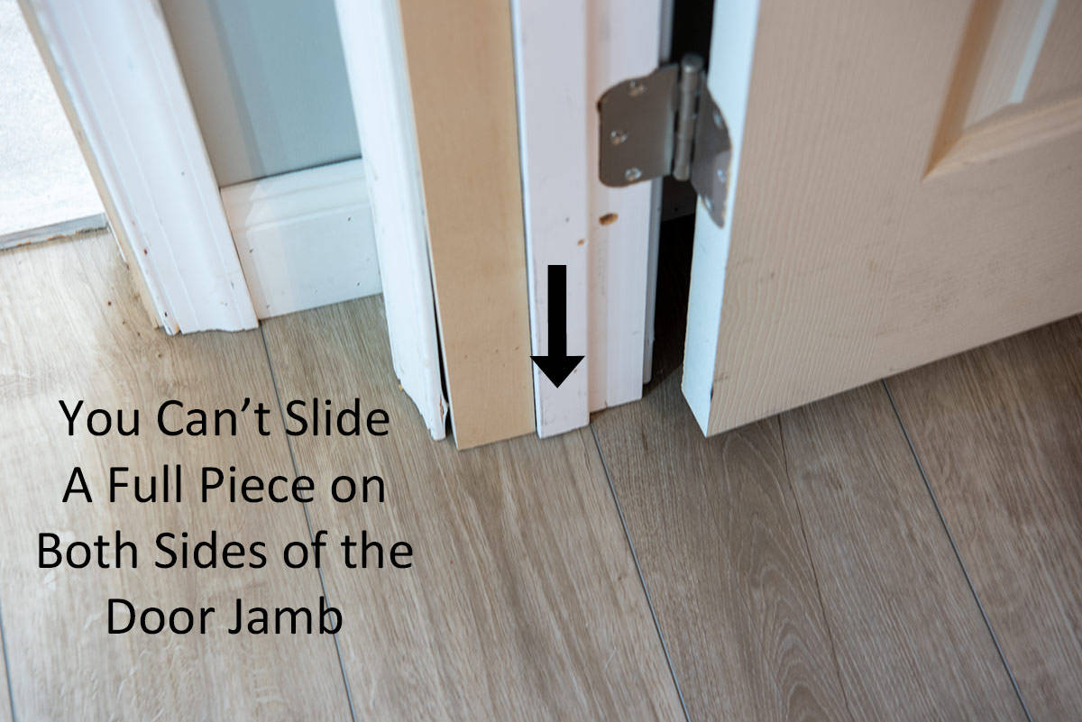 Looking down at floor near door jamb to show that you cannot use a full piece of flooring to cover both sides.