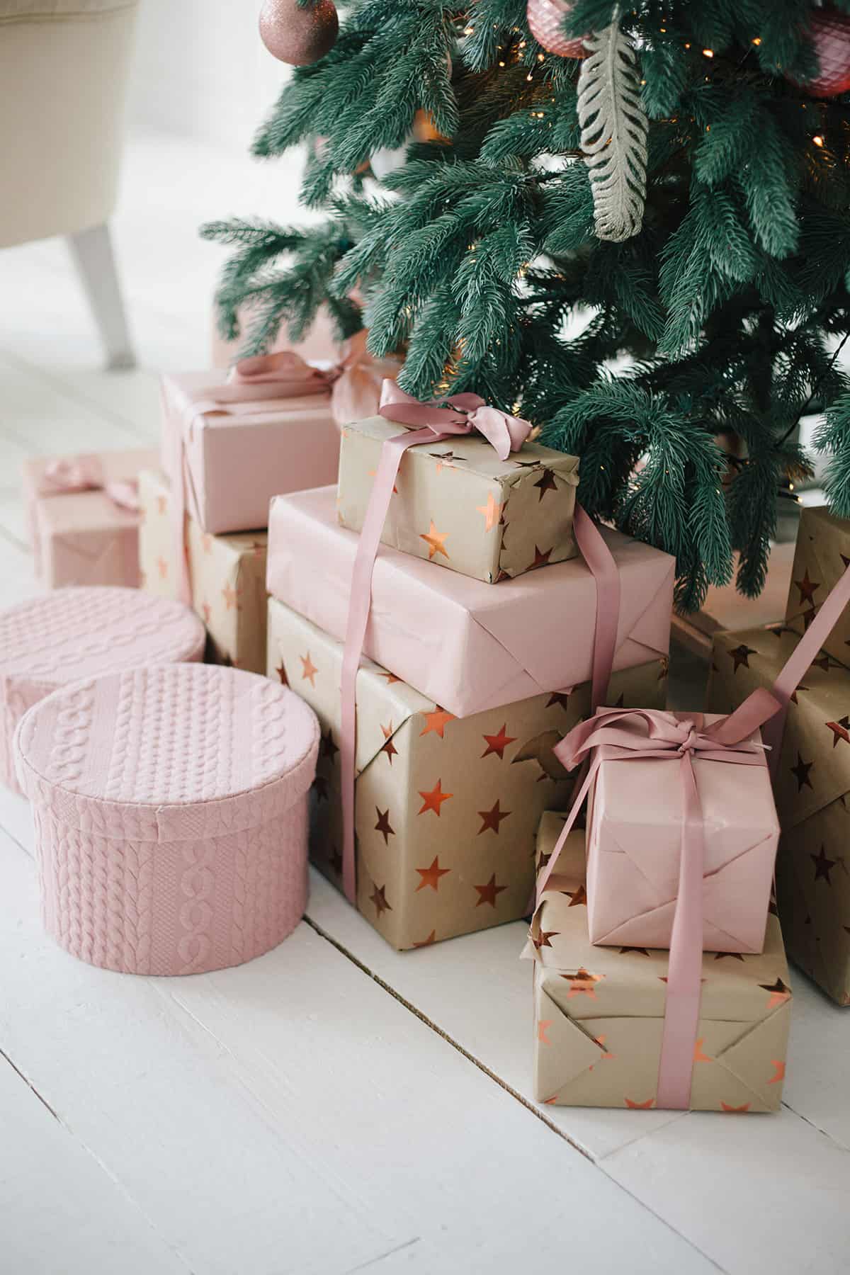 Pastel soft pink presents under a Christmas tree.