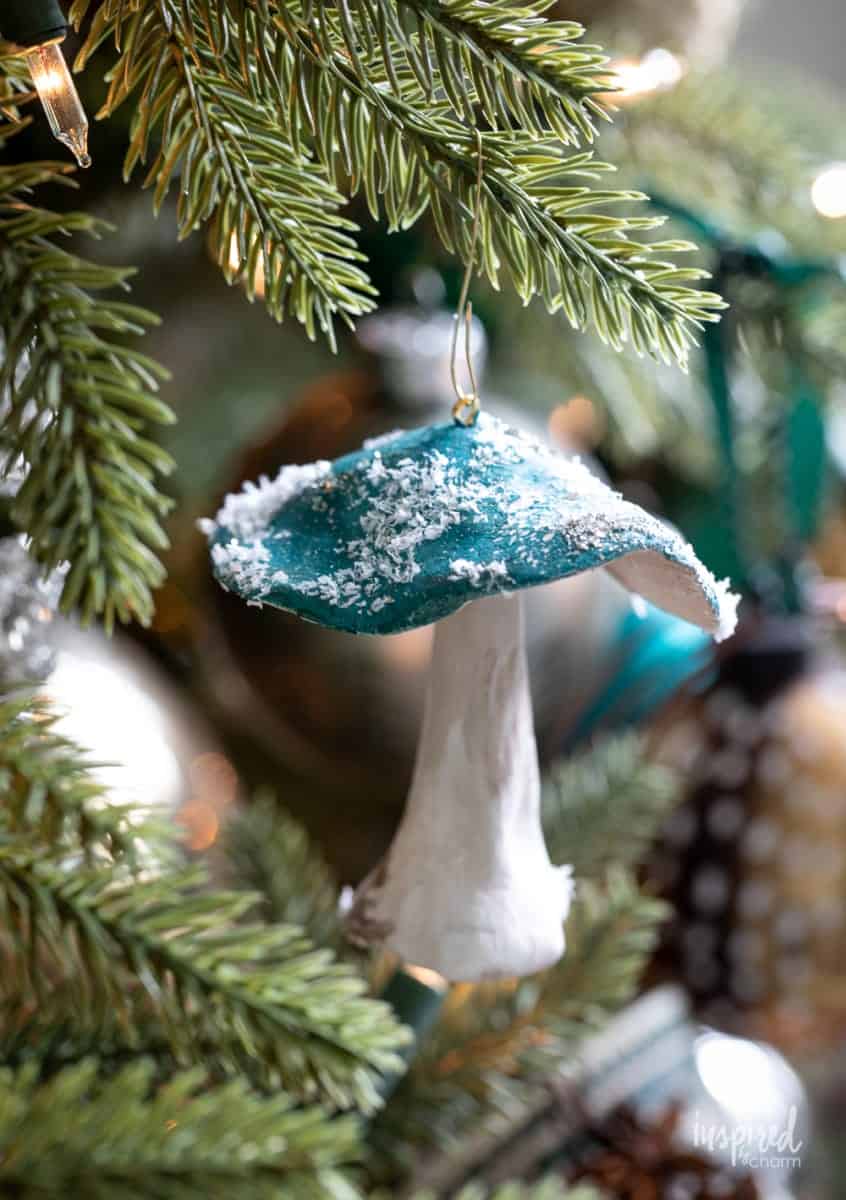 Clay snow-capped Mushroom Christmas tree ornament, features blue cap and white stem with natural looking texture and imperfections.