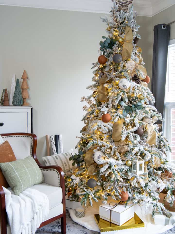 Natural Christmas tree lit up with earthy decorations.