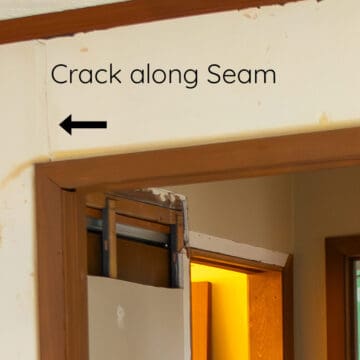Cracked drywall seam above a door frame where two sheets of drywall create a seam.