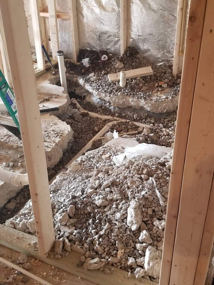 Concrete floor ripped out to reroute new plumbing for a bathroom.
