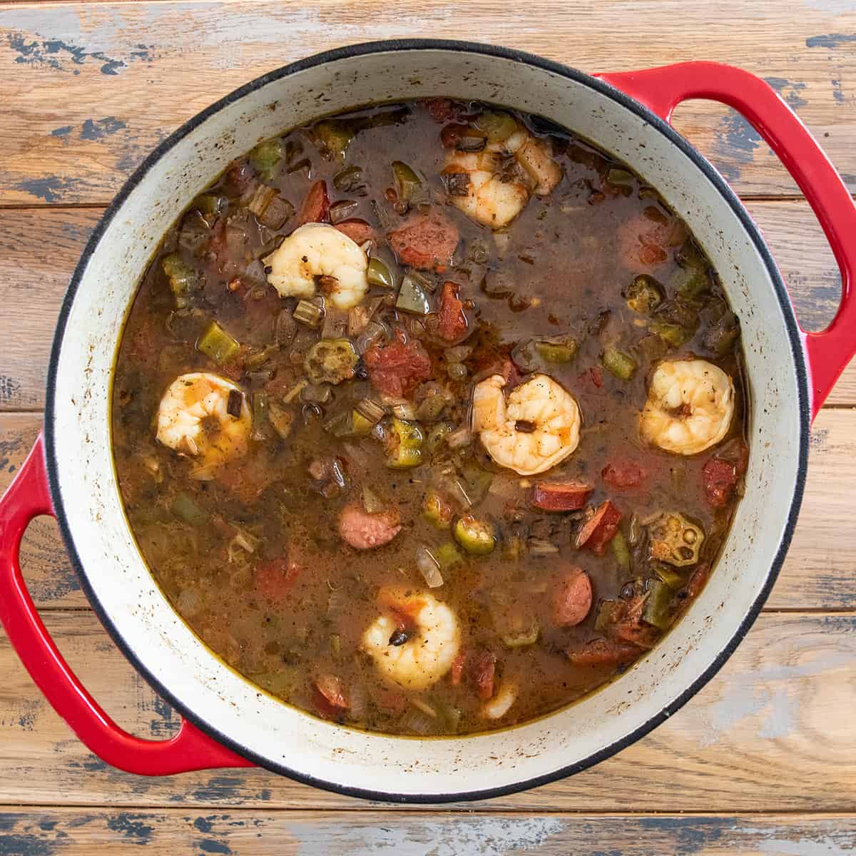 Overhead of a pot of Creole seafood gumbo with shrimp, sausage, and okra.