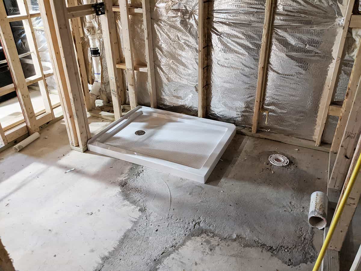 A bathroom remodel after the new plumbing is installed into concrete floors.