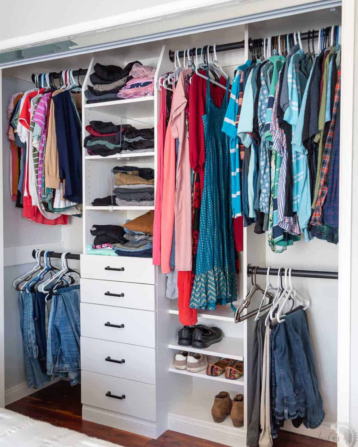 Whiter closet with center drawer divider for a his and hers closet.