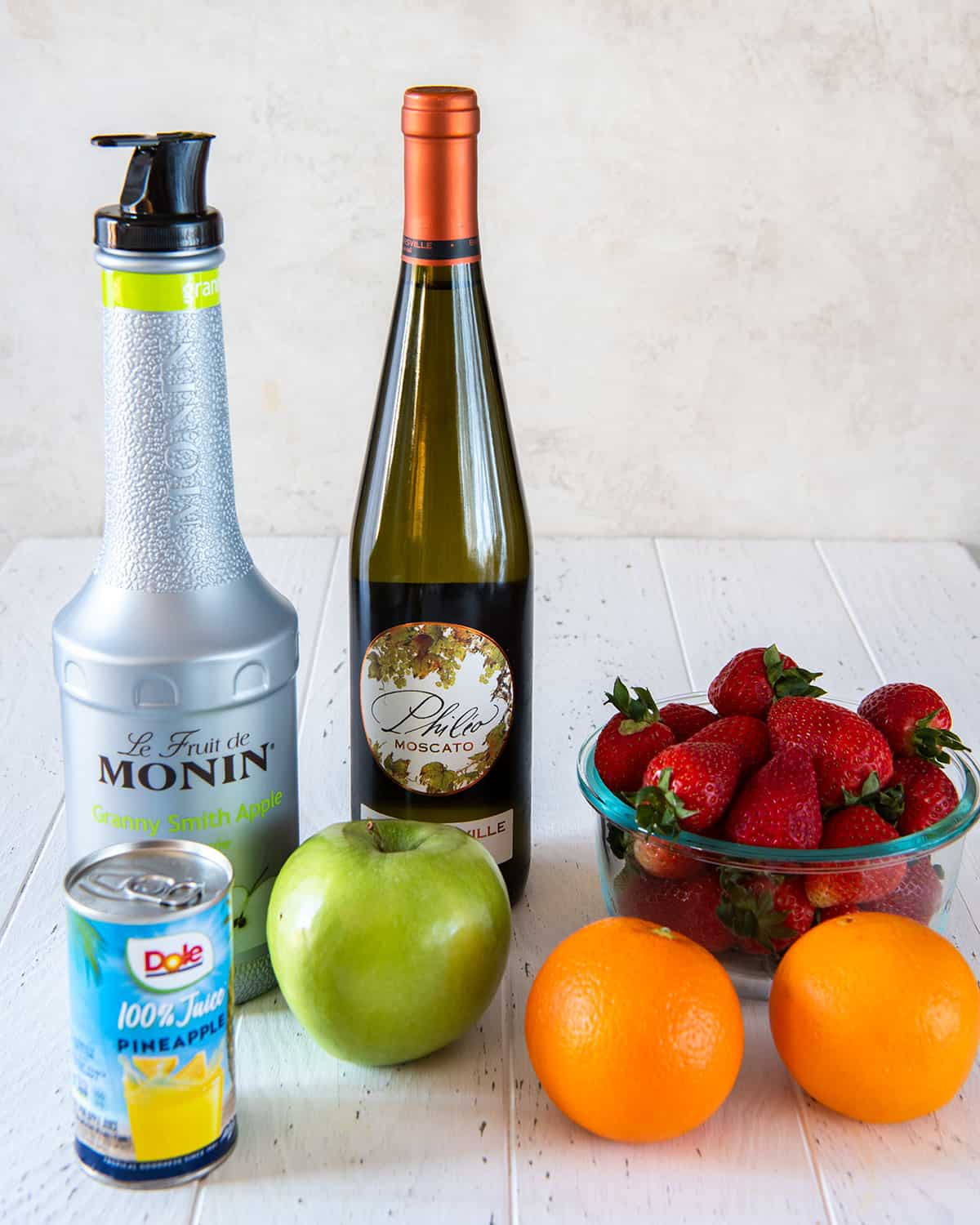 Ingredients to make green apple sangria including Moscato wine and granny smith apple puree.
