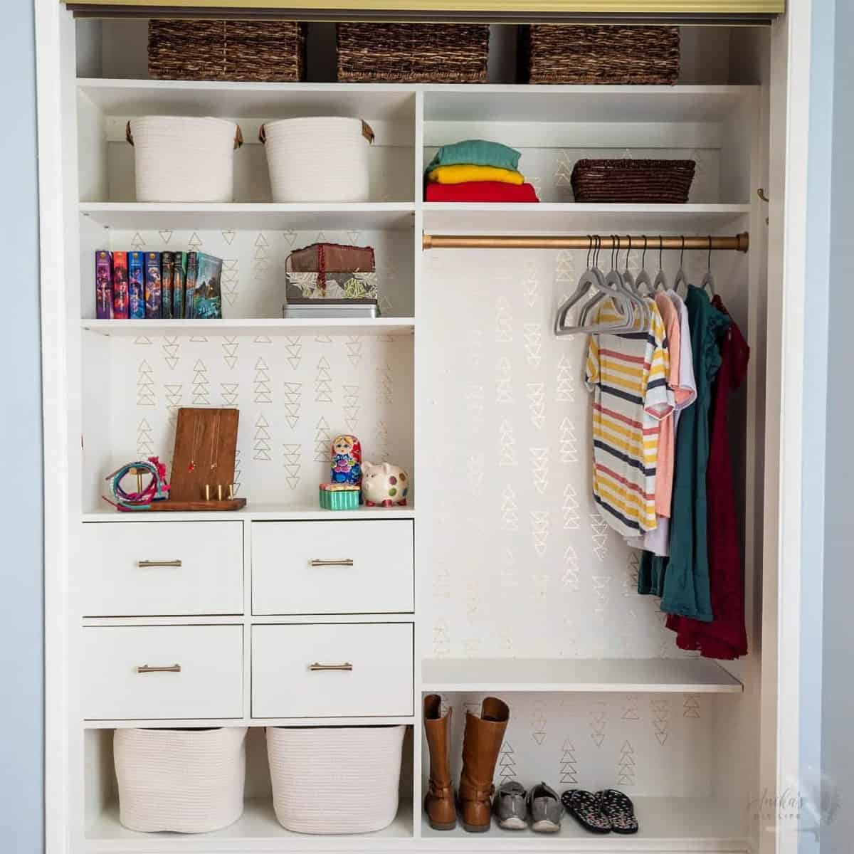 An organized closet with drawers, cubbies, hangers, and baskets for shoes.
