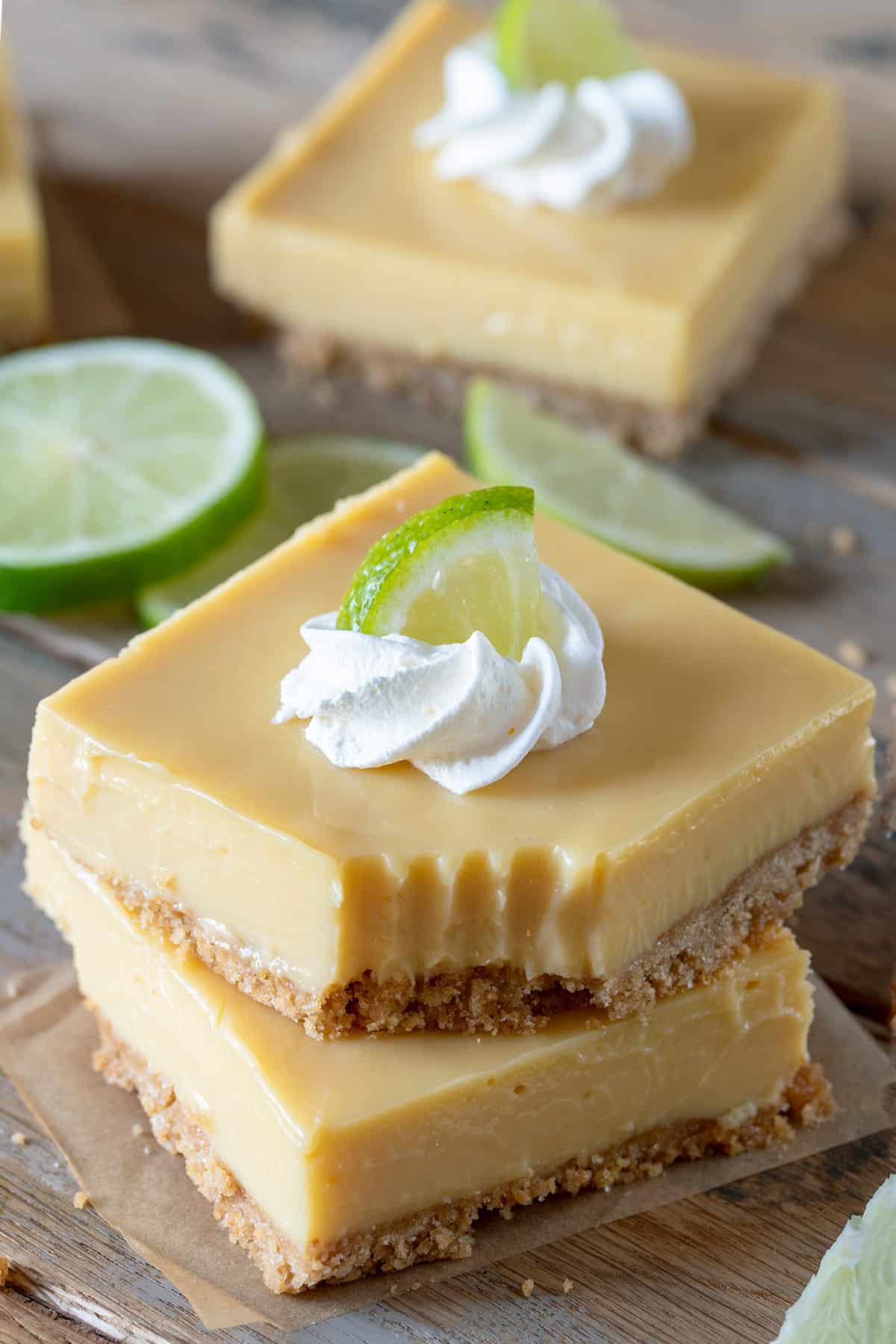 Two stacked key lime bars with a fork bite taken out of the top bar.