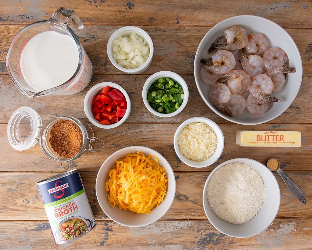 Ingredients to make shrimp and grits laid out on a table in small bowls.
