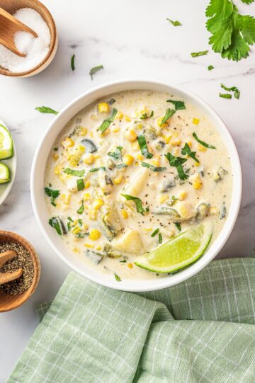 Overhead of a bowl of creamy corn and poblano pepper soup.