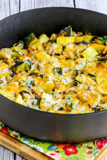 A pot of calabacitas or Mexican zucchini casserole in a skillet topped with cheese.