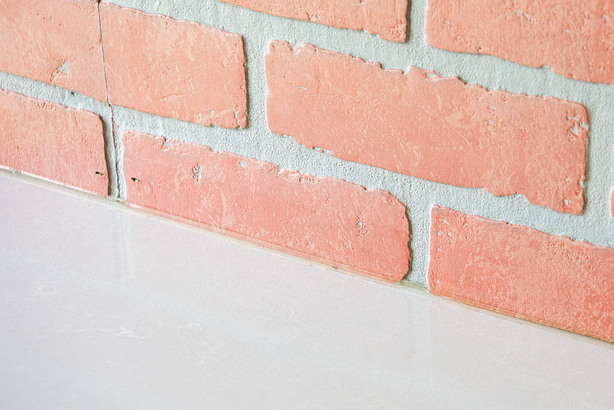 Line of crystal clear caulk between a backsplash and countertop.