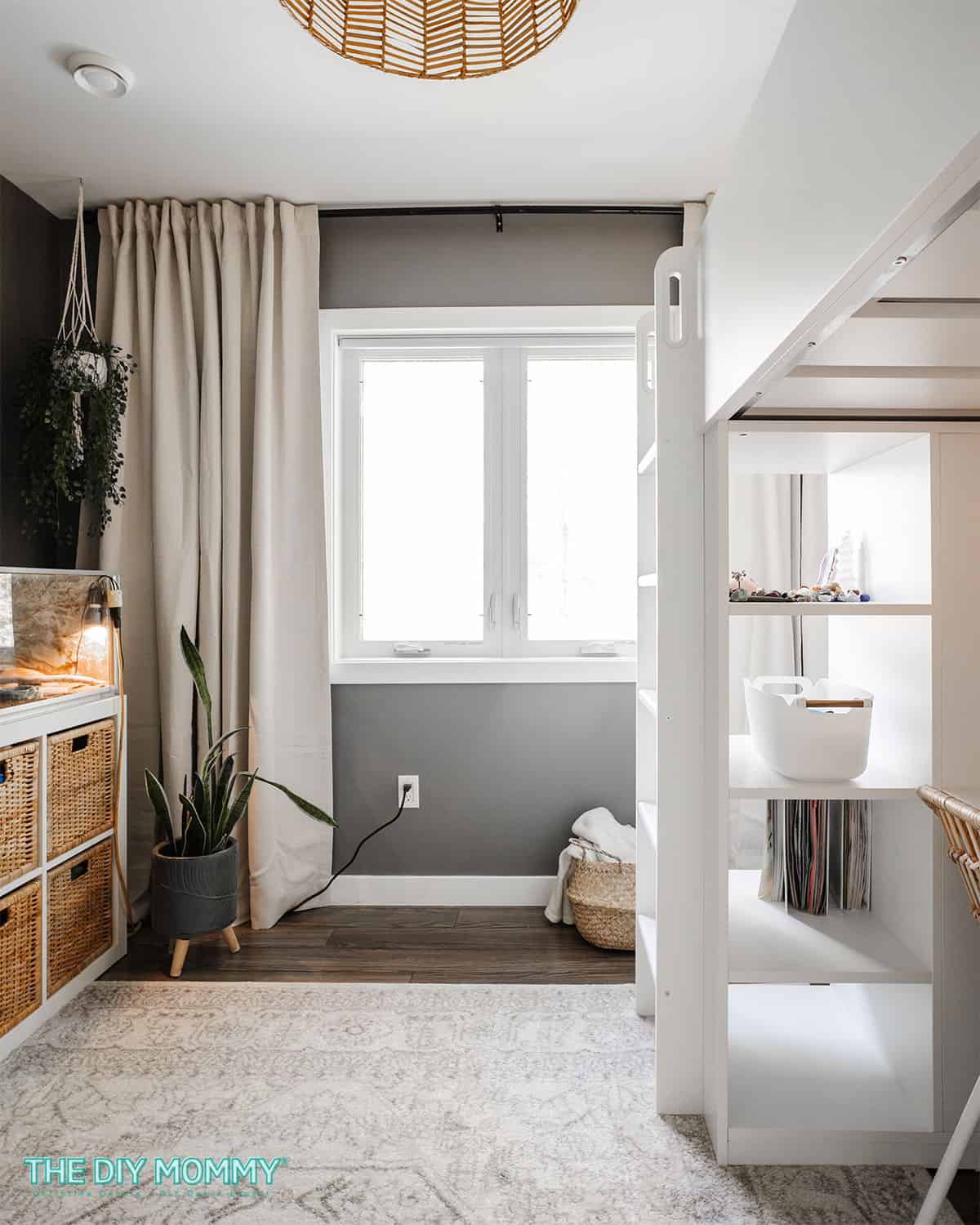 Moody teen bedroom with white furniture, dark gray walls, and natural wood furniture.
