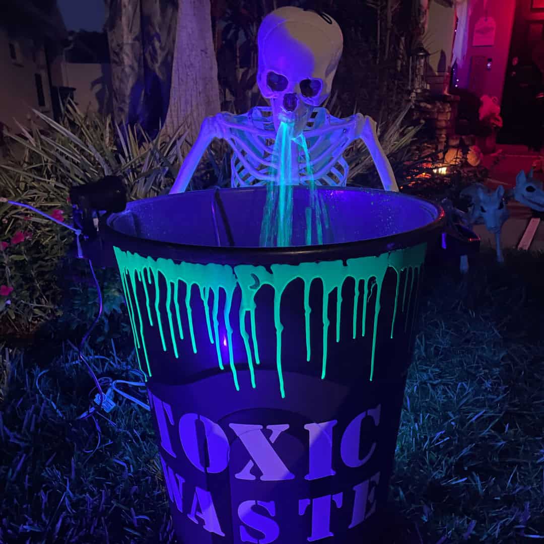 A basic trash pail gets a Halloween makeover with glow-in-the-dark green paint, highlighter ink, a black light, and a creepy skeleton.