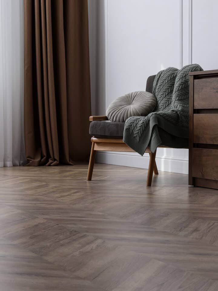 A chair sitting on a herringbone vinyl floor.