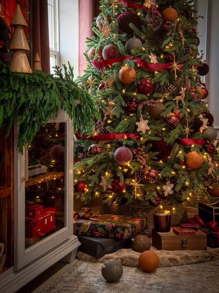 Sideview of a moody Christmas tree with brown and red decorations on the tree and sparkle.