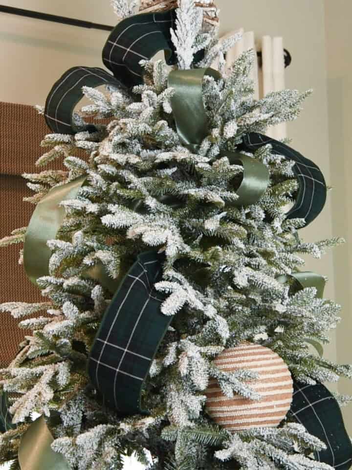 Christmas tree with green ribbon in multiple patterns.