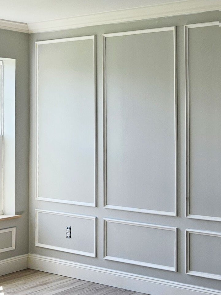 Picture frame molding on a gray wall next to a window.